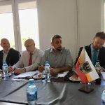 Spotkanie biznesowe przy stole z flagą i butelkami wody na pierwszym planie